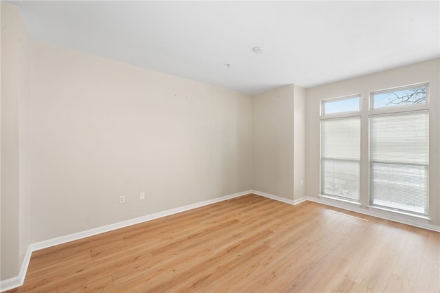 spare room featuring light wood-style flooring and baseboards