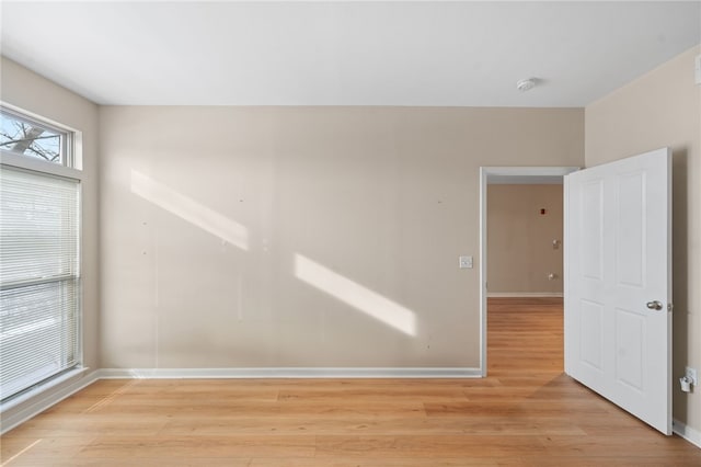 spare room with light wood finished floors and baseboards