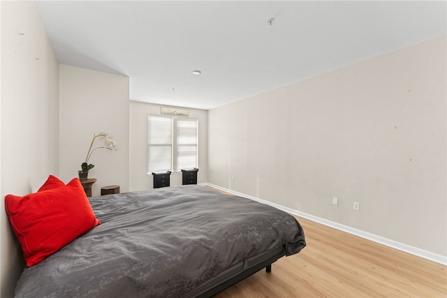 bedroom featuring baseboards and wood finished floors