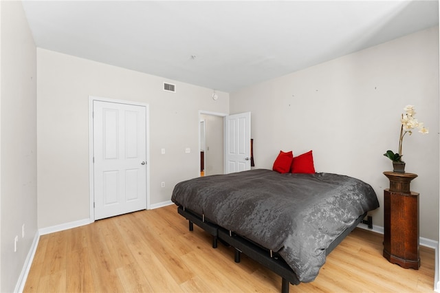 bedroom with light wood finished floors, baseboards, and visible vents