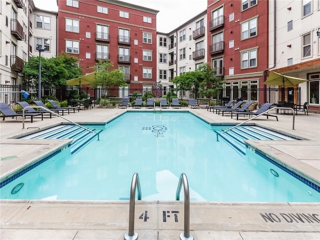 view of swimming pool with a patio area and fence