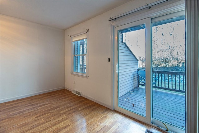 doorway with light wood-type flooring, baseboards, and visible vents