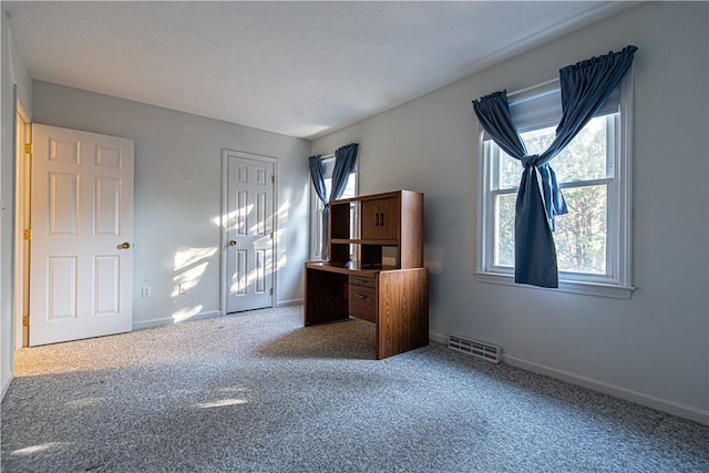 unfurnished bedroom featuring a closet, carpet, visible vents, and baseboards