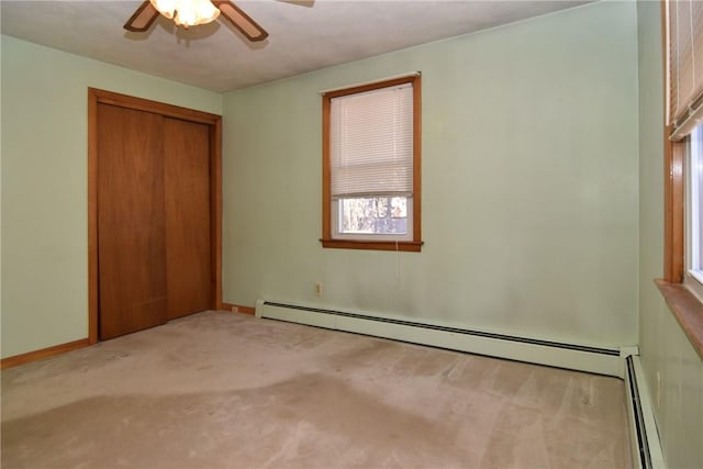 unfurnished bedroom with light carpet, a ceiling fan, a baseboard heating unit, a baseboard radiator, and baseboards