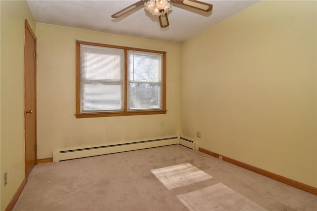 spare room featuring light carpet, ceiling fan, a baseboard heating unit, and baseboards