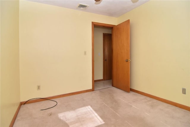 unfurnished room with visible vents, light colored carpet, and baseboards