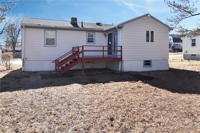 back of house featuring a chimney, stairway, and a wooden deck