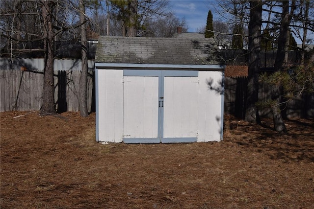 view of storm shelter with a storage unit, an outdoor structure, and fence