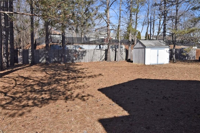 view of yard featuring a storage unit, an outbuilding, and fence