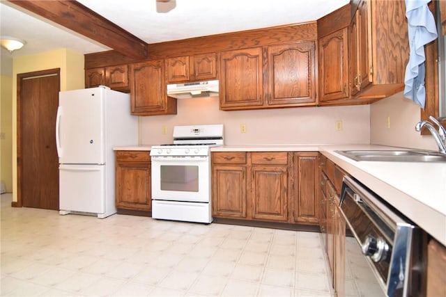 kitchen with white appliances, light floors, a sink, light countertops, and under cabinet range hood