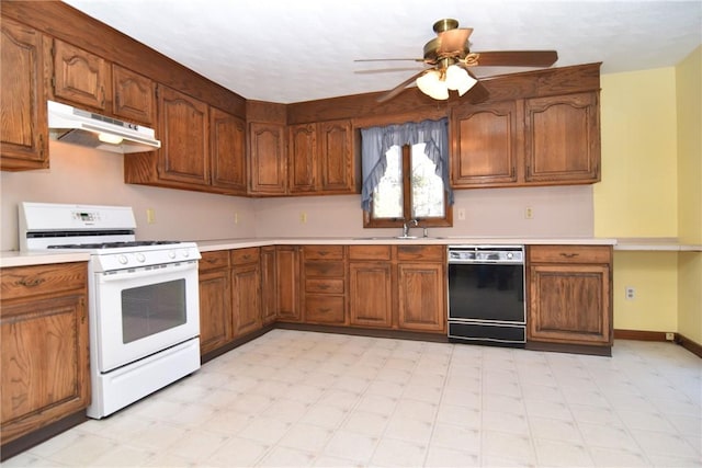 kitchen with light countertops, gas range gas stove, under cabinet range hood, and black dishwasher