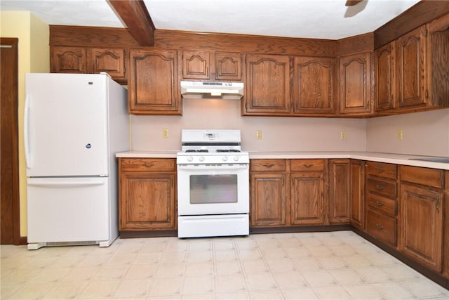 kitchen with under cabinet range hood, light floors, white appliances, and light countertops