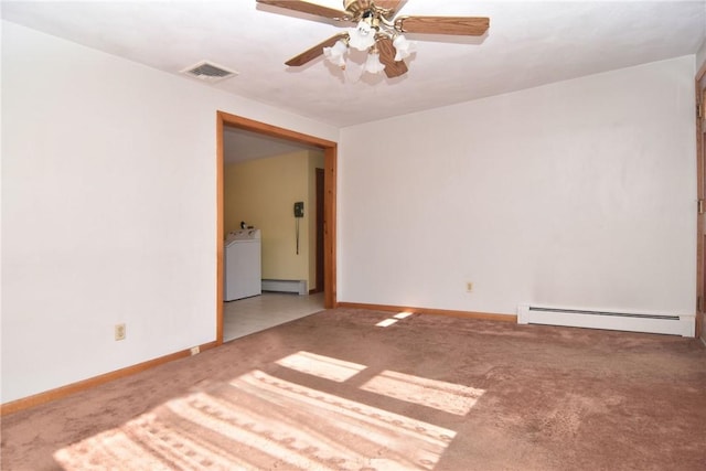 carpeted empty room featuring visible vents, baseboards, baseboard heating, and washer / dryer