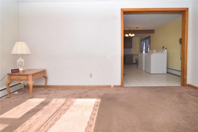 carpeted empty room featuring washer and clothes dryer, baseboard heating, a chandelier, and baseboards