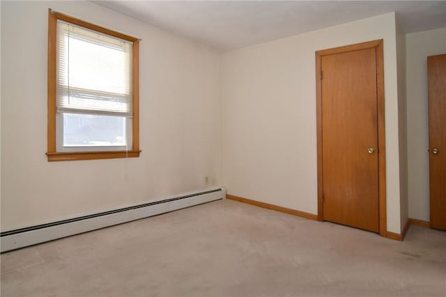 unfurnished room featuring light carpet, baseboard heating, and baseboards