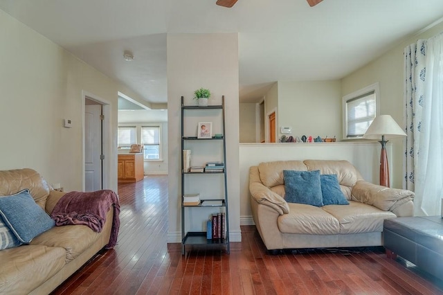 living area featuring dark wood-style floors, a ceiling fan, and baseboards