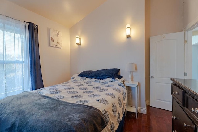 bedroom with lofted ceiling and dark wood-style flooring