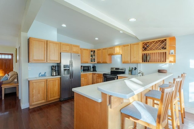 kitchen featuring appliances with stainless steel finishes, light countertops, vaulted ceiling, and light brown cabinets