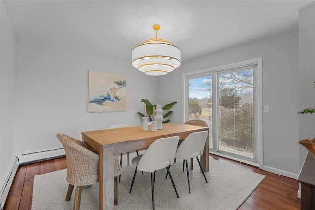 dining space featuring baseboard heating, baseboards, and wood finished floors