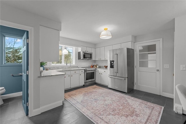 kitchen with white cabinetry, baseboards, tasteful backsplash, and appliances with stainless steel finishes