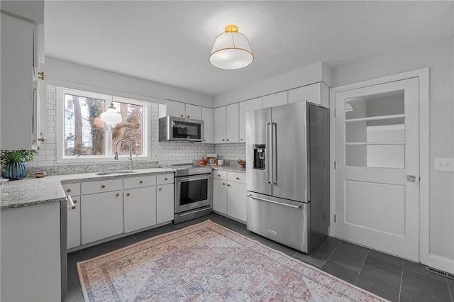 kitchen featuring a sink, white cabinets, backsplash, and stainless steel appliances