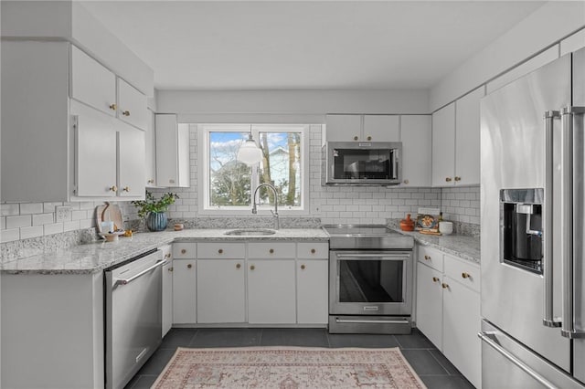 kitchen featuring a sink, stainless steel appliances, dark tile patterned floors, and decorative backsplash