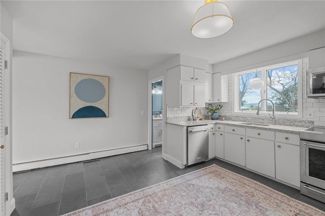 kitchen featuring white cabinetry, a sink, decorative backsplash, appliances with stainless steel finishes, and a baseboard heating unit