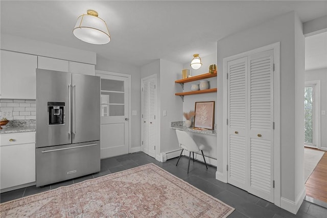 kitchen featuring open shelves, a baseboard heating unit, high quality fridge, and white cabinets