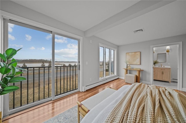 bedroom featuring baseboard heating, light wood-style floors, visible vents, and access to outside