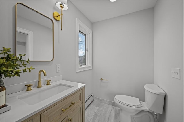 bathroom with vanity, toilet, baseboards, and a baseboard radiator