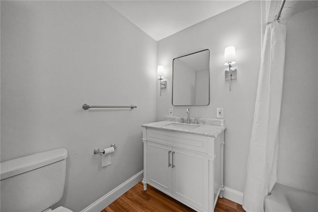 full bath featuring baseboards, toilet, wood finished floors, and vanity