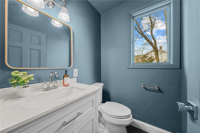 bathroom featuring vanity, toilet, and baseboards