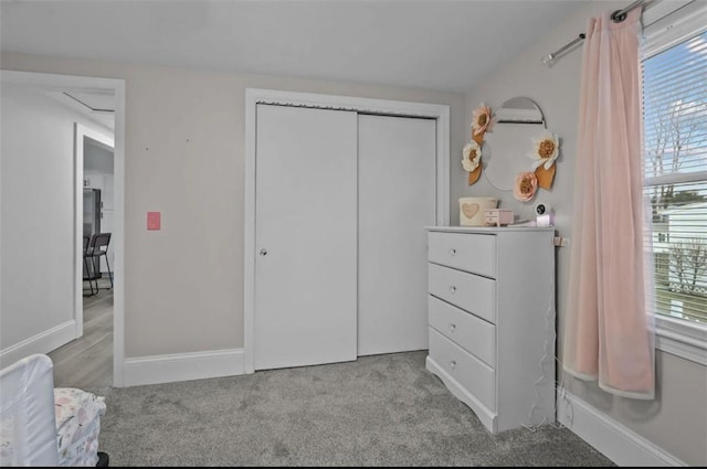 carpeted bedroom featuring baseboards and a closet