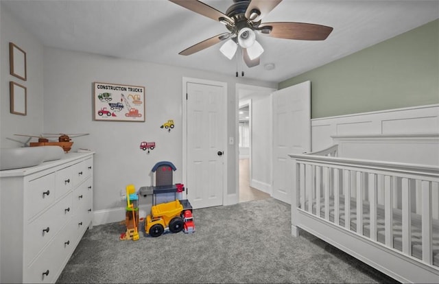 carpeted bedroom featuring ceiling fan and a crib