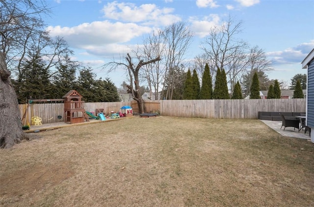 view of yard featuring a patio area, a fenced backyard, and a playground