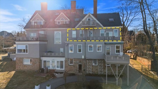 view of front of property featuring stone siding, french doors, and stucco siding