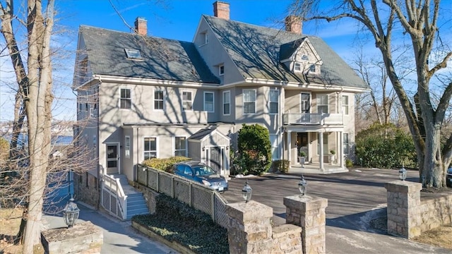 exterior space featuring a chimney and a balcony