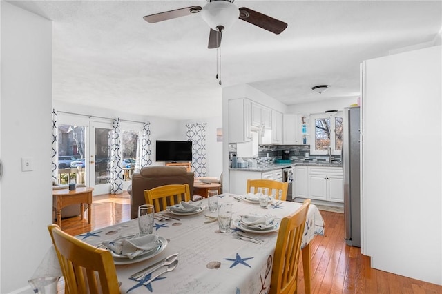 dining area featuring ceiling fan and light wood-type flooring