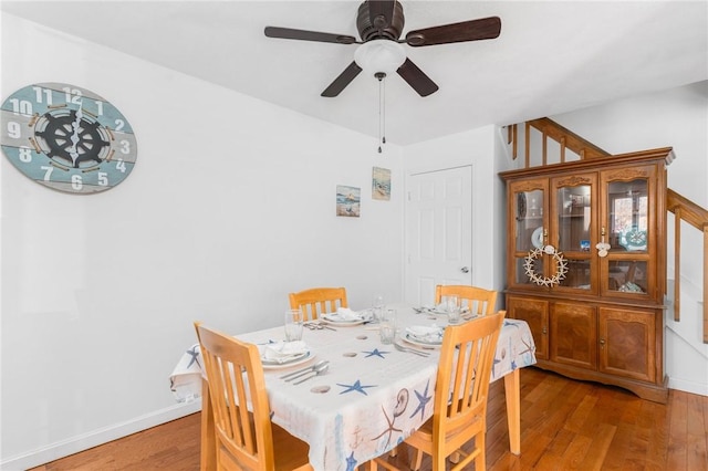 dining area with a ceiling fan, light wood-type flooring, and baseboards