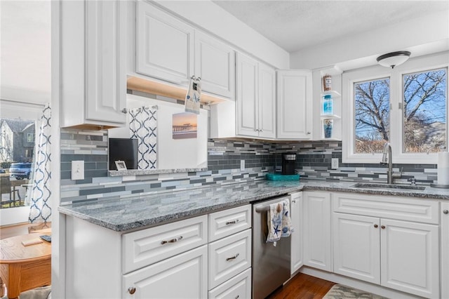 kitchen with stainless steel dishwasher, white cabinets, and a sink