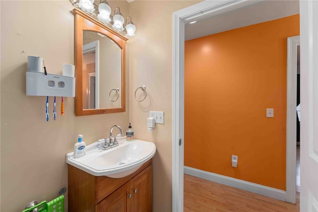 bathroom featuring vanity, baseboards, and wood finished floors