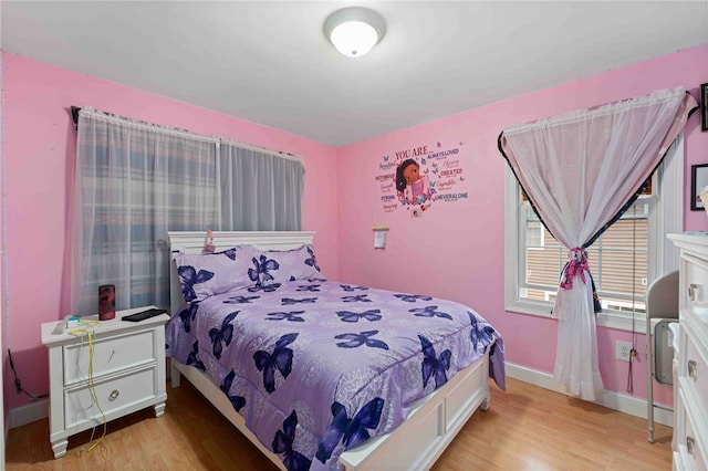 bedroom with light wood-style flooring and baseboards