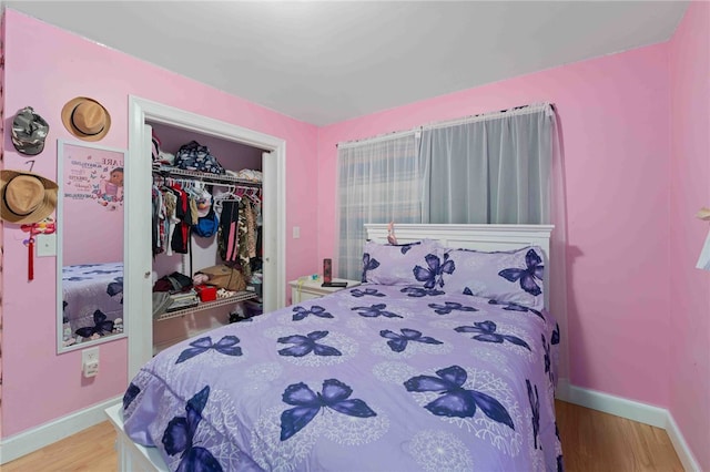 bedroom featuring a closet, baseboards, and wood finished floors