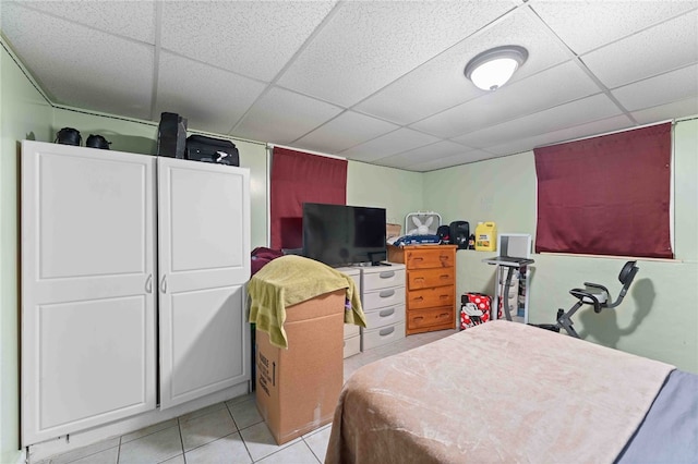 bedroom featuring a paneled ceiling and light tile patterned flooring