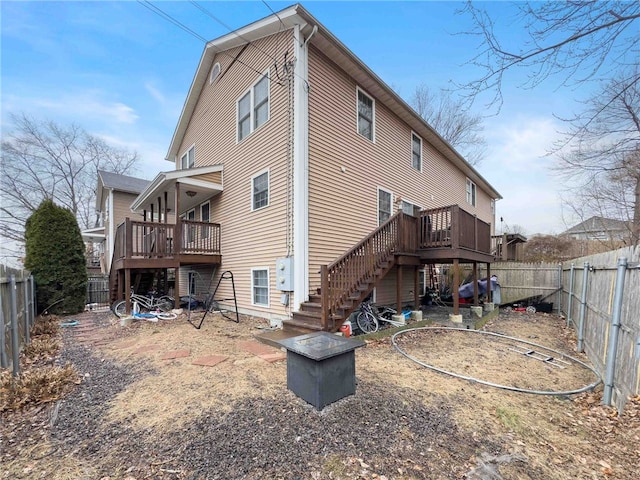 rear view of property with a fenced backyard, stairway, and a wooden deck