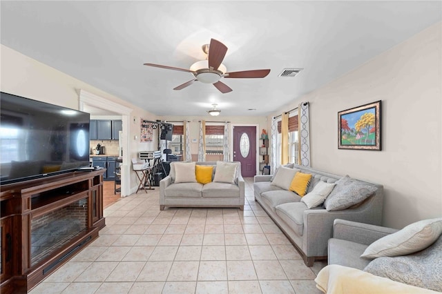 living room with visible vents, ceiling fan, and light tile patterned floors