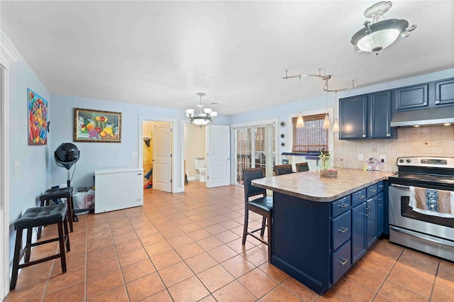 kitchen with blue cabinets, under cabinet range hood, fridge, stainless steel electric range, and decorative backsplash