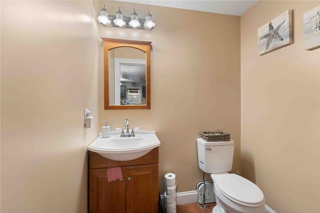 bathroom featuring toilet, vanity, and baseboards