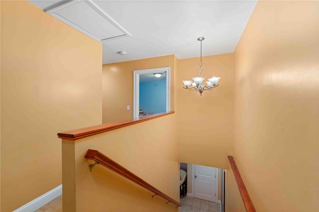 stairs with an inviting chandelier and baseboards