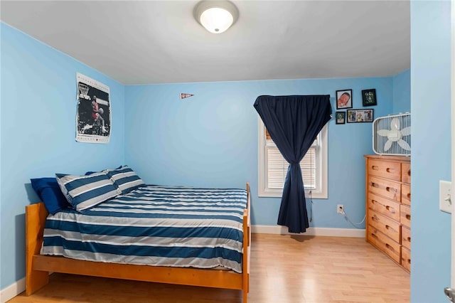 bedroom with baseboards and wood finished floors